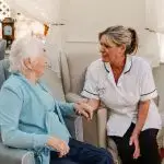 nursing staff sit with care home resident's in Bolton's leading residential care home Starmount Villa