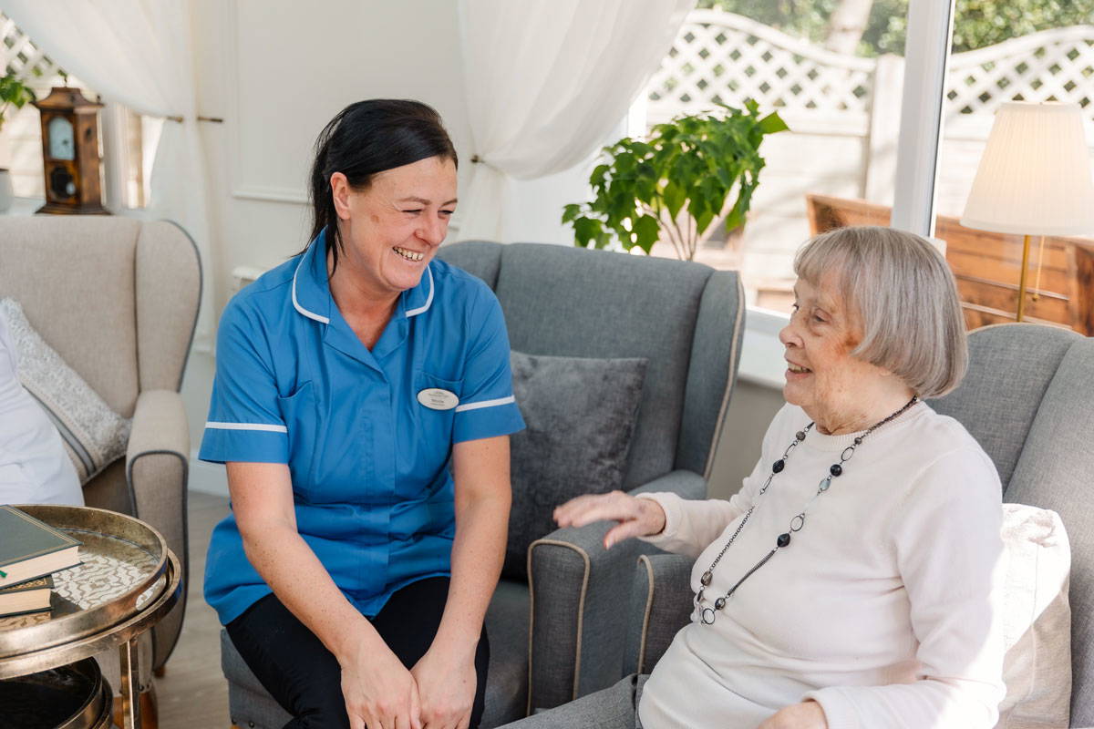 nursing staff sit with care home resident in Bolton's finest residential care home Starmount Villa